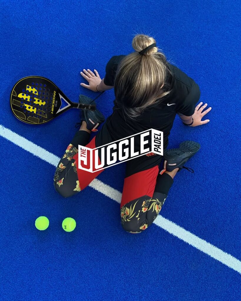 a woman sitting on the ground with a racket and balls